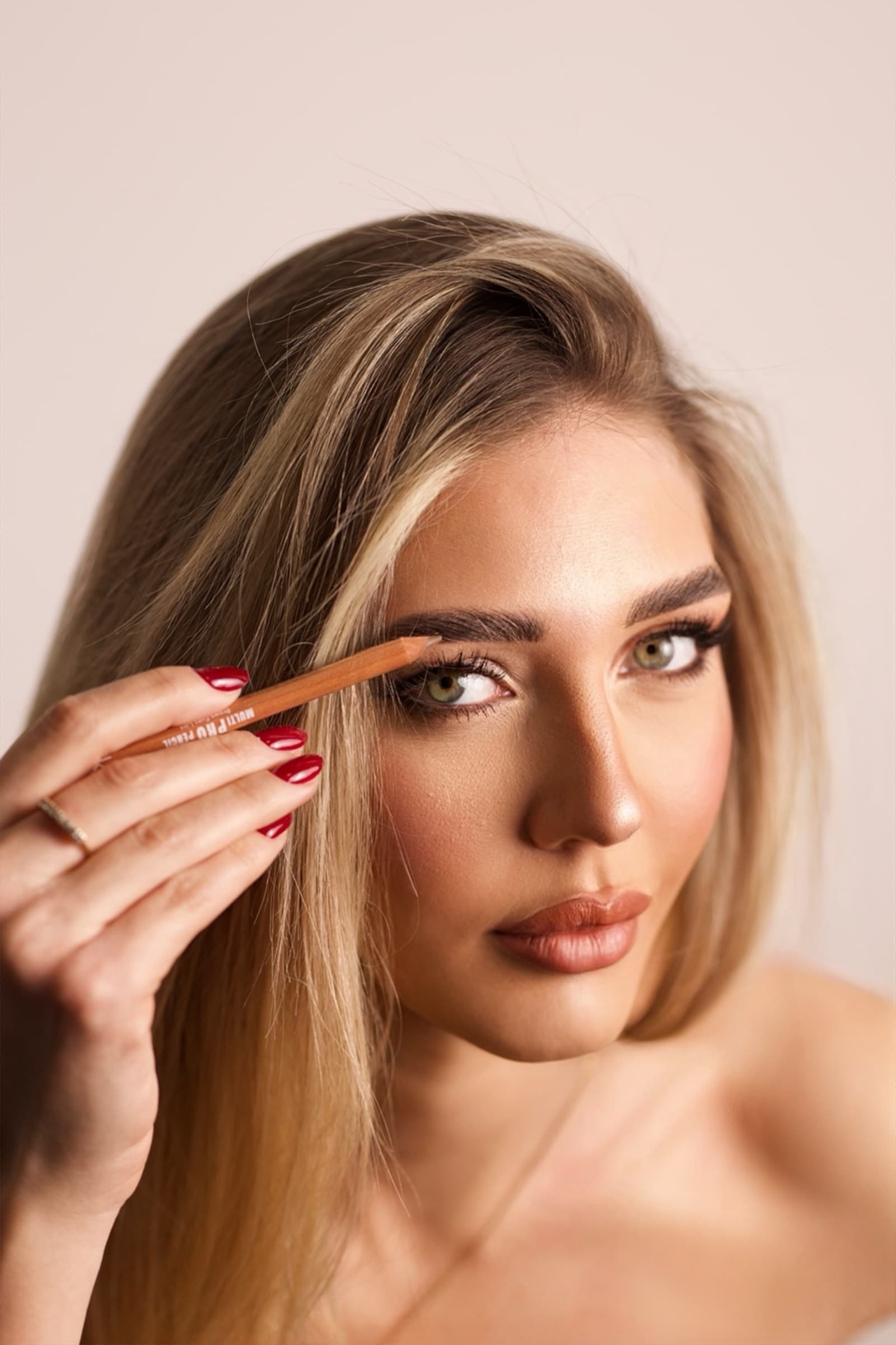 A brush shaping the brow, skin lit soft and close