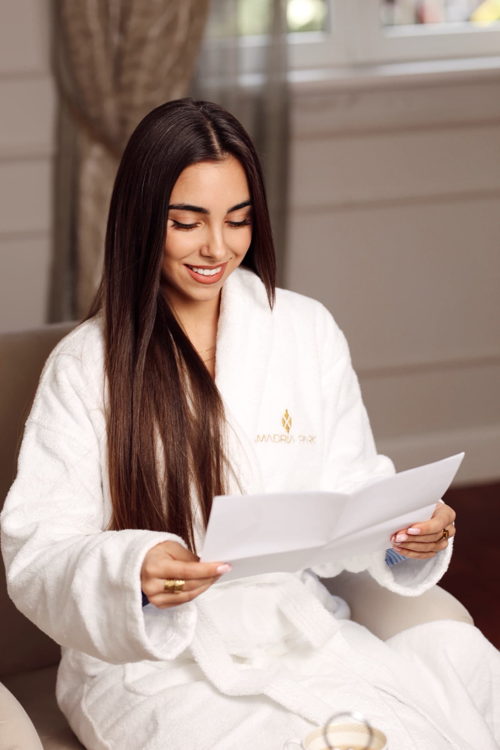 Reading a welcome letter in the suite, robe and morning light