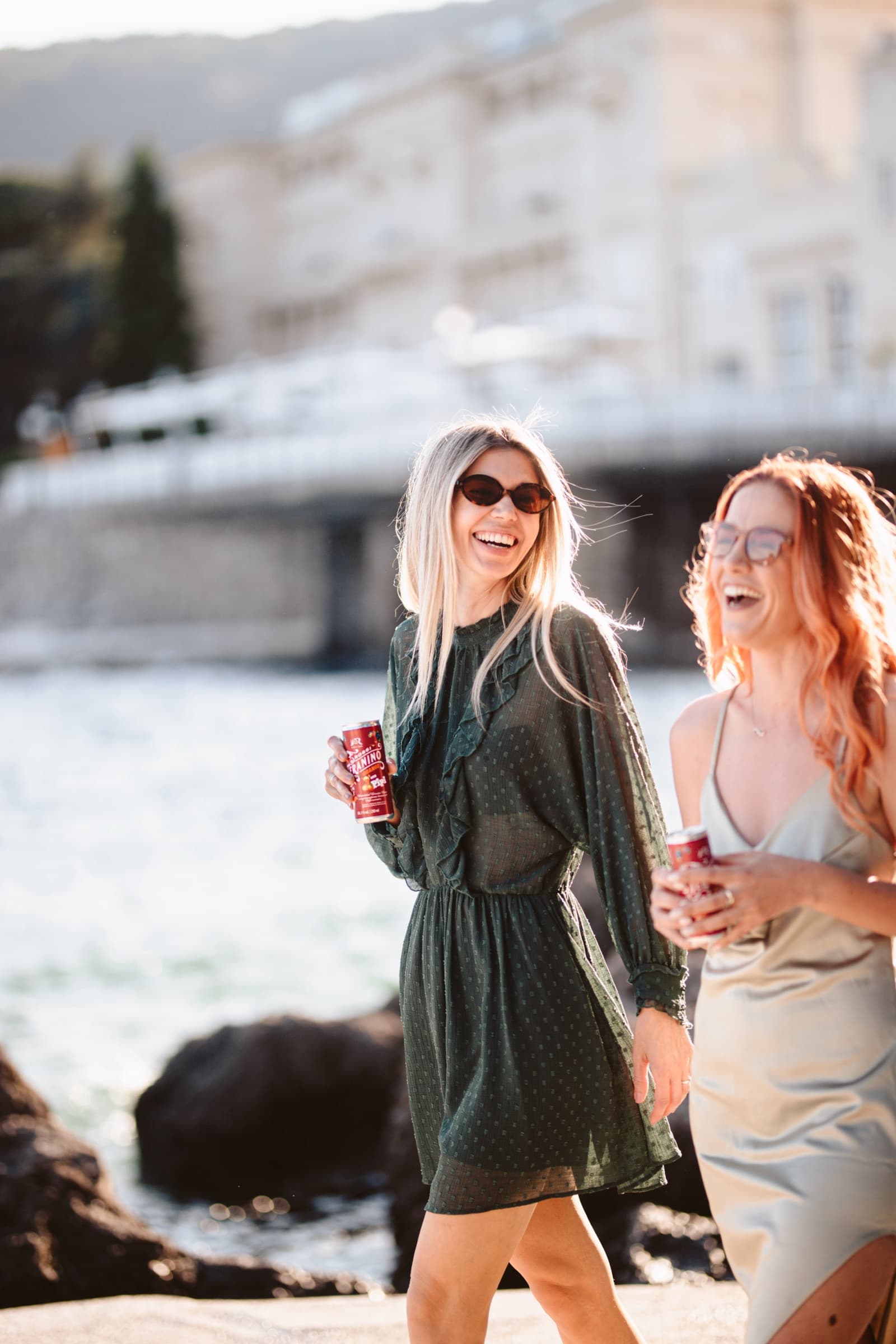 Two friends laughing on the shore, Teranino cans in hand