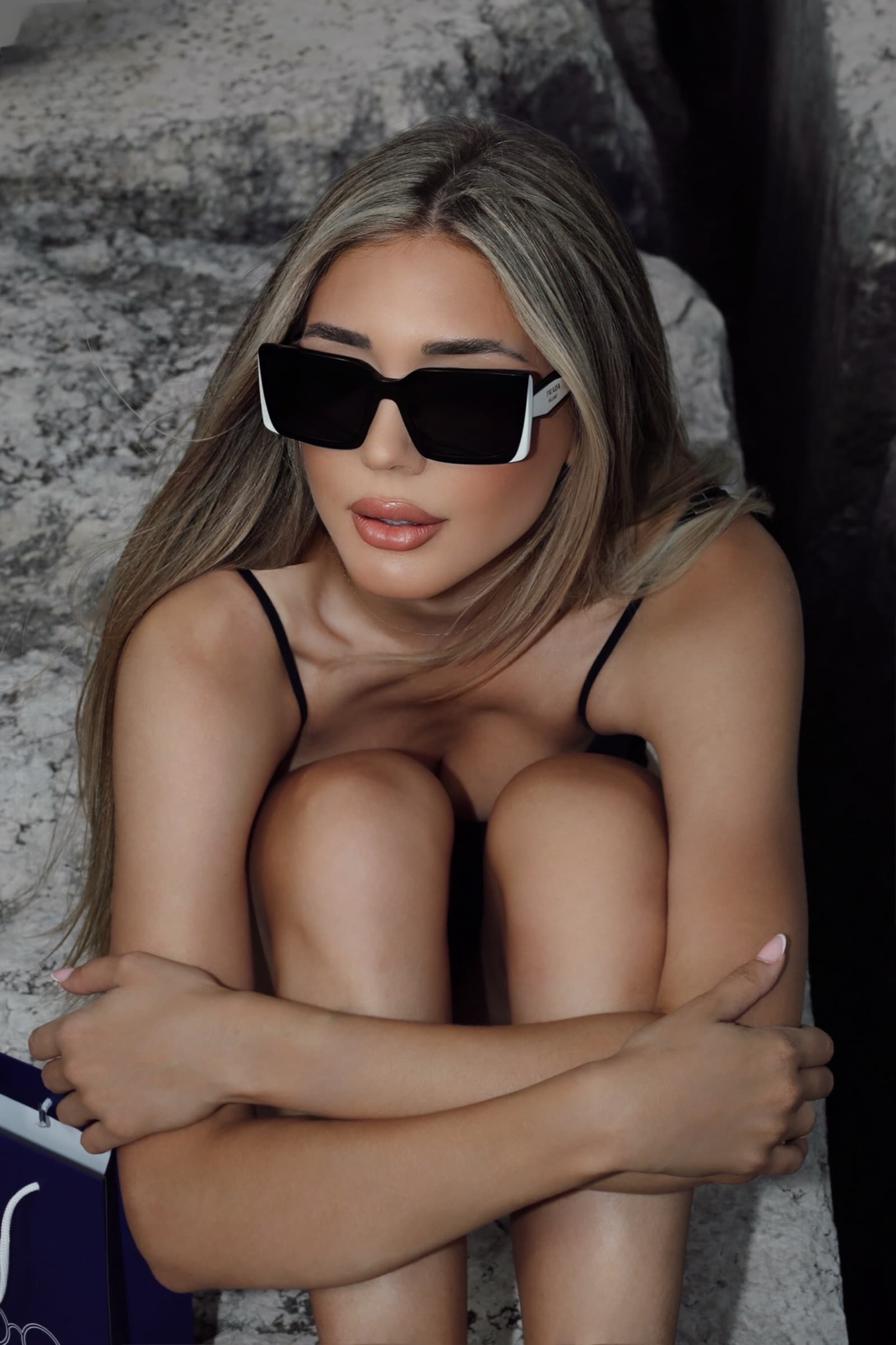 White rectangular sunglasses, seated against the rock