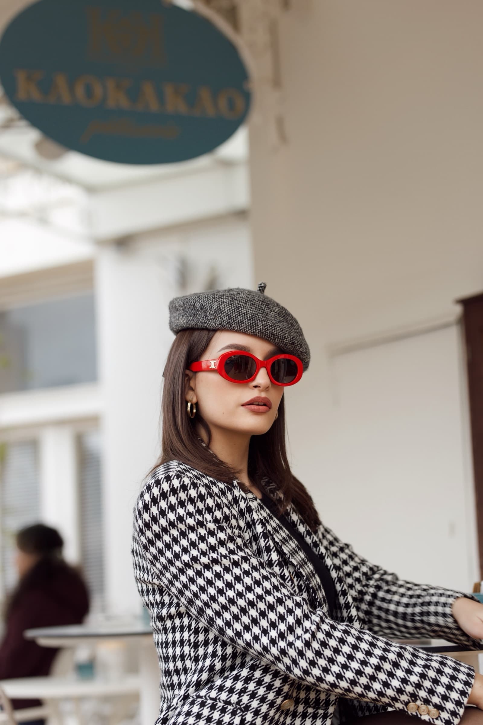 Red sunglasses and a grey beret outside a cafe