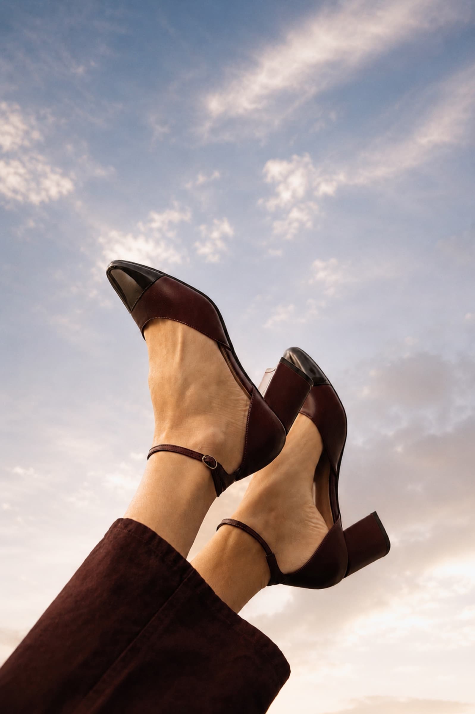 Suede ankle boots raised against an open sky