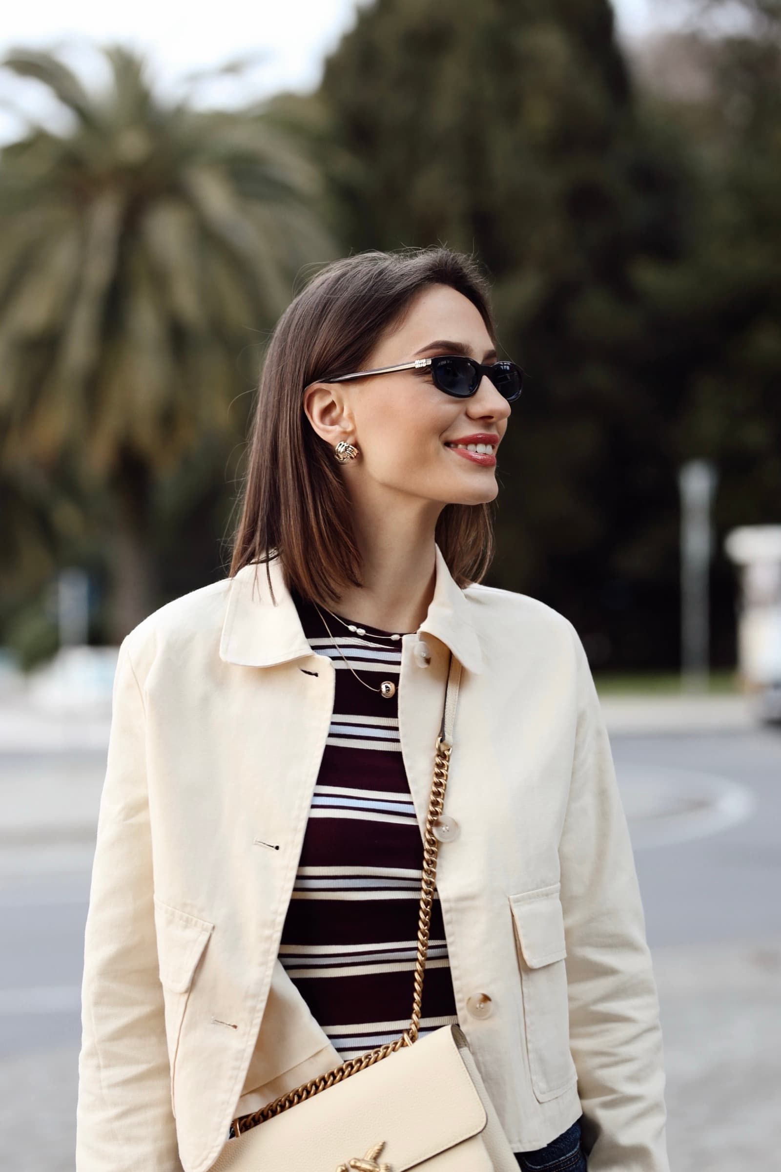 Cream overshirt and a striped knit with a chain bag