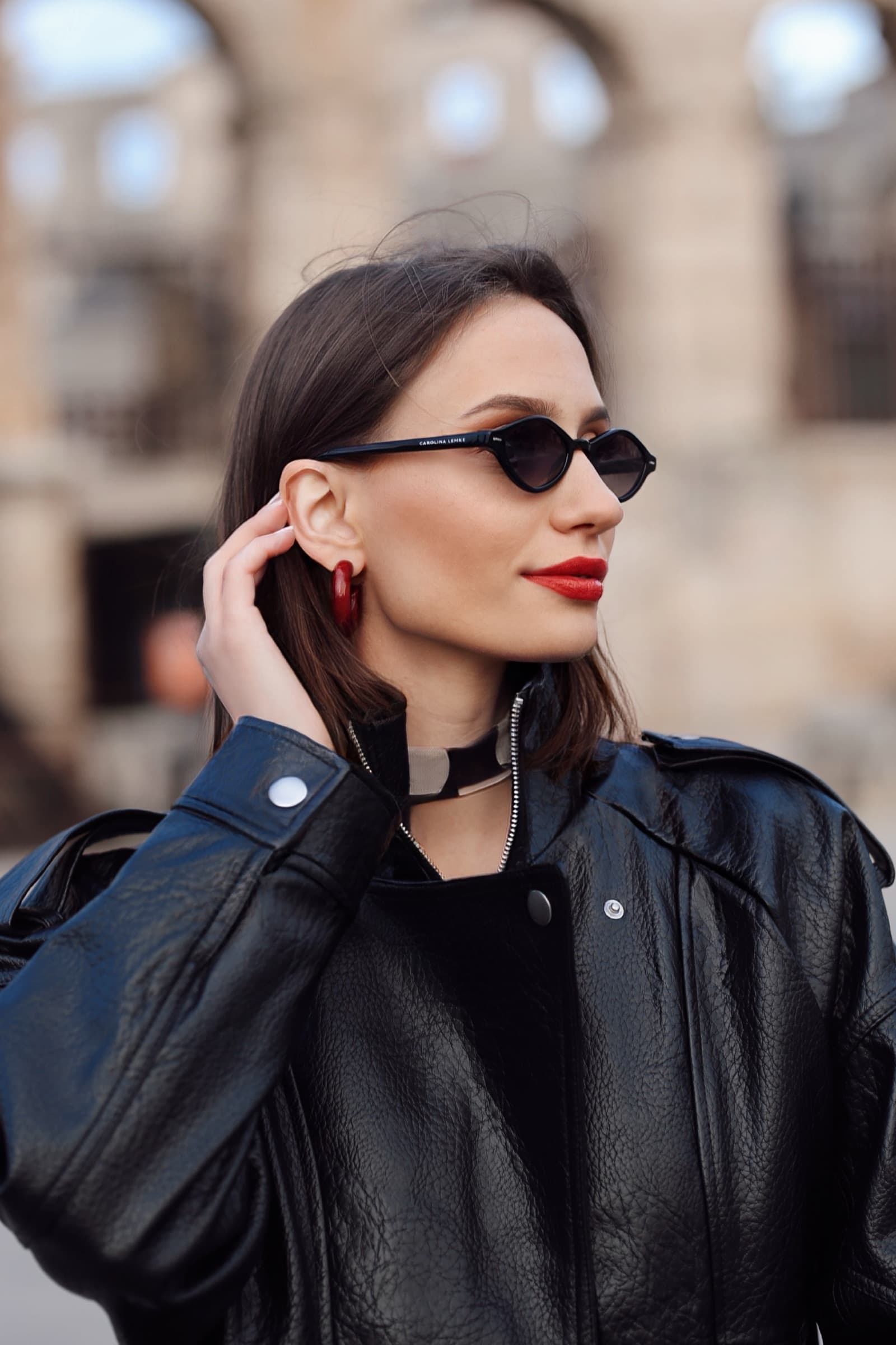 Black leather bomber and a red lip outside the Roman arena