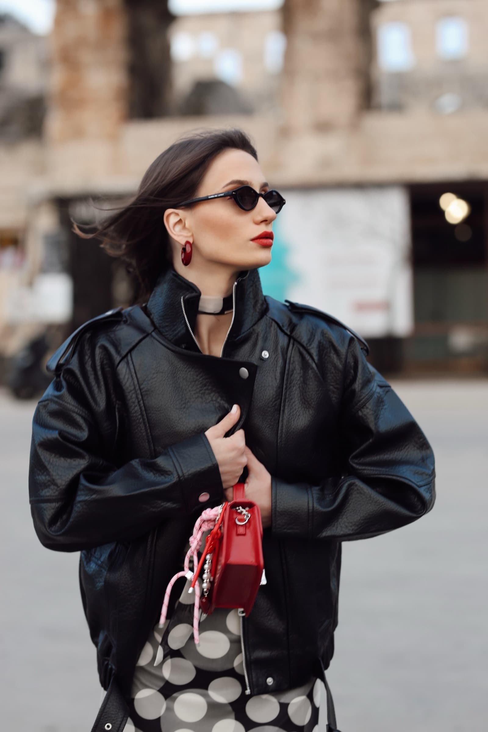 Black leather bomber, red mini bag and a polka-dot skirt