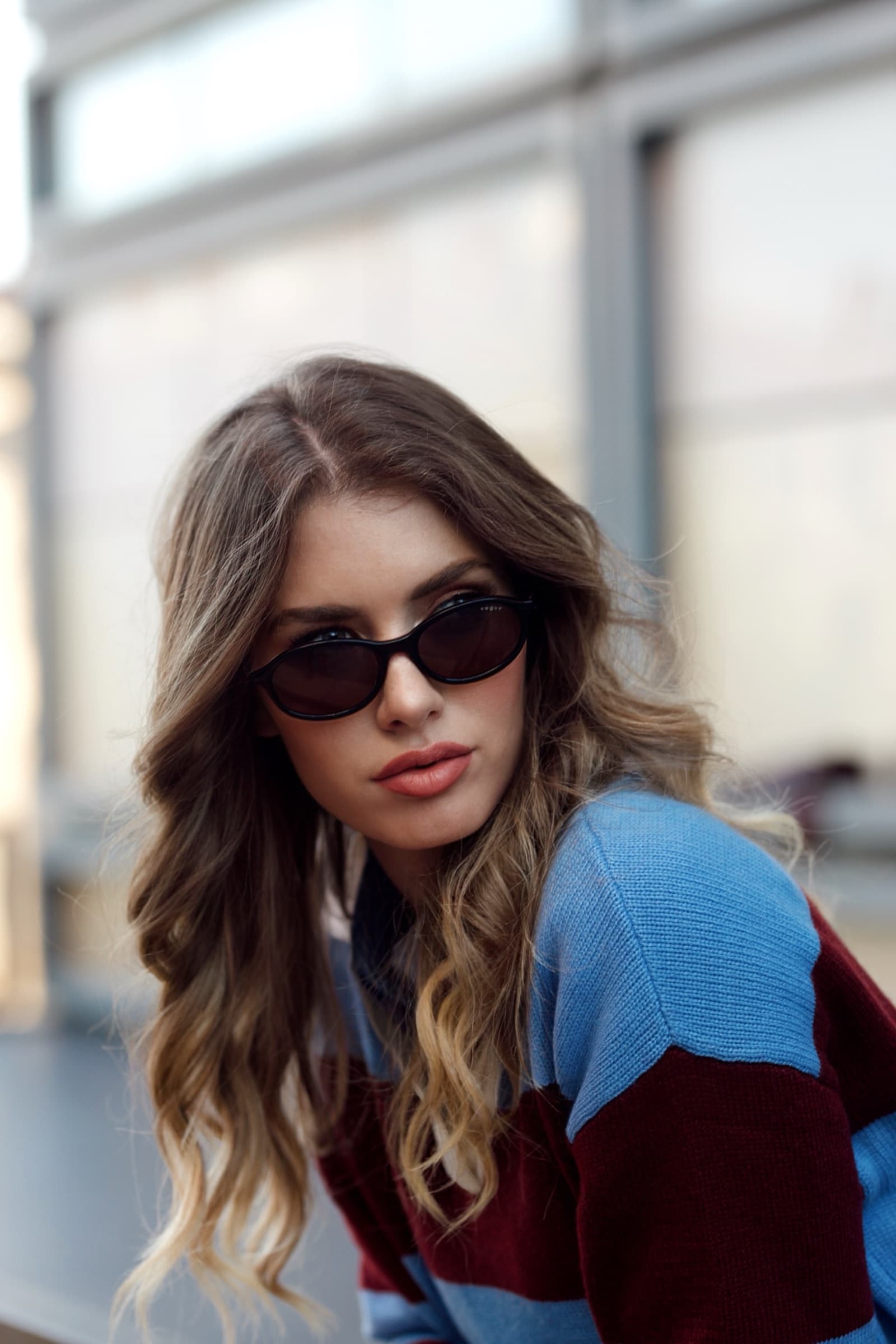 Colour-blocked knit and slim sunglasses by the window