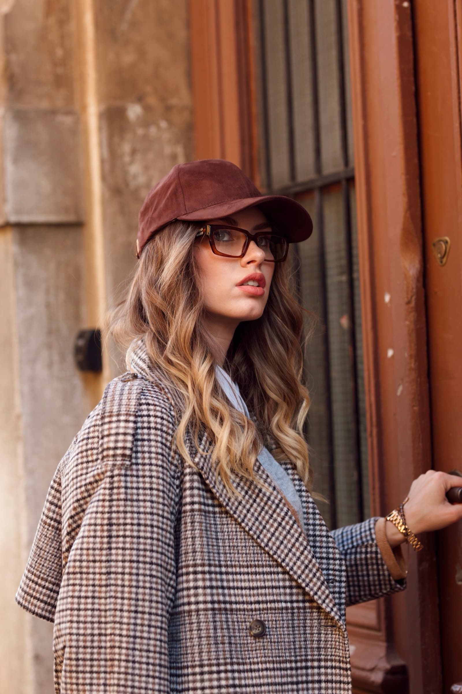 Check blazer, leather cap and clear frames on the street
