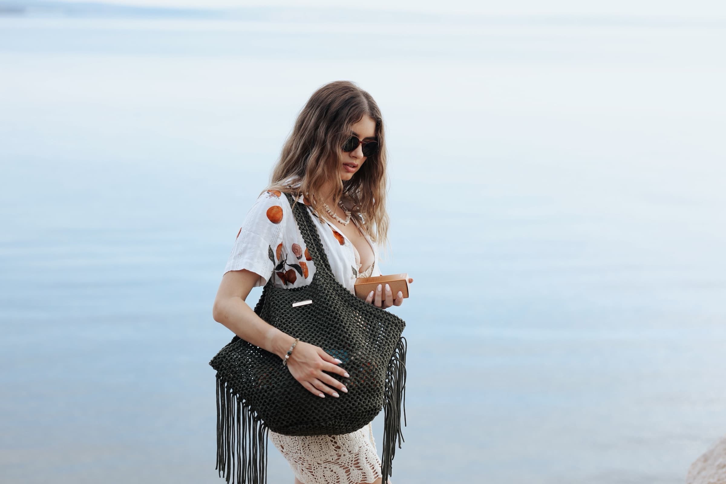 Full length on the shoreline, fringed bag over the shoulder